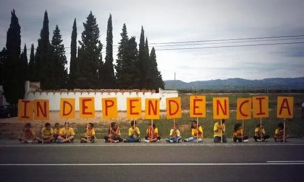 Grup de nens i nenes amb la paraula independència al tram 68 de la Via Catalana